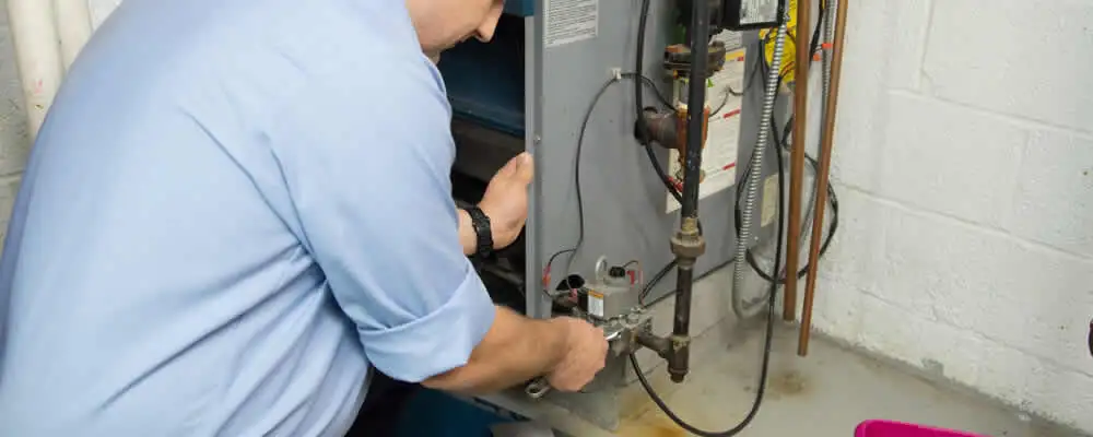 Furnace repair technician inspecting and servicing a home heating system in Norton, MA