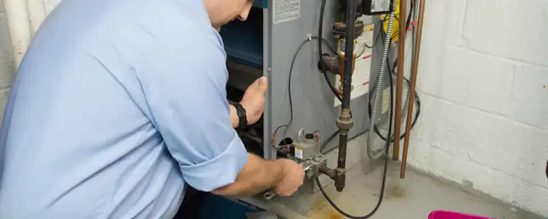 Furnace repair technician inspecting and servicing a home heating system in Norton, MA