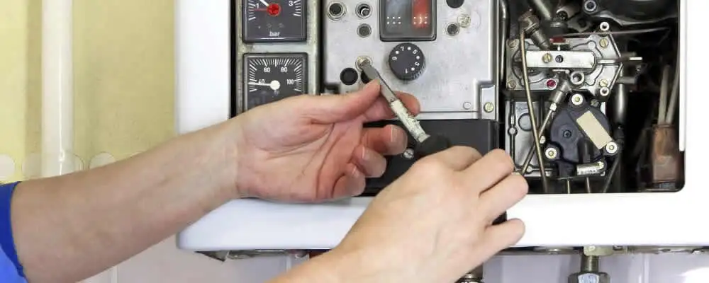 Heating repair technician adjusting boiler controls and components in Norton, MA